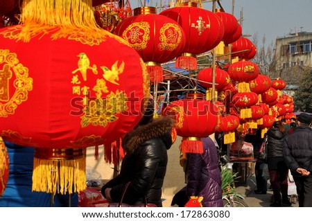 Pengzhou, China January 22, 2014:  People shopping at vendors\' booths where they sell decorations for the Chinese Lunar New Year holiday
