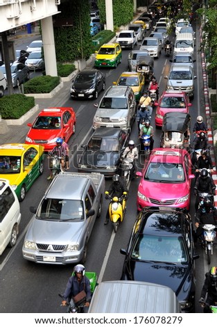 Bangkok, Thailand  December 24, 2013:  Bumper-to-bumper cars, taxis, and vans on Sukhamvit Road during the evening rush hour