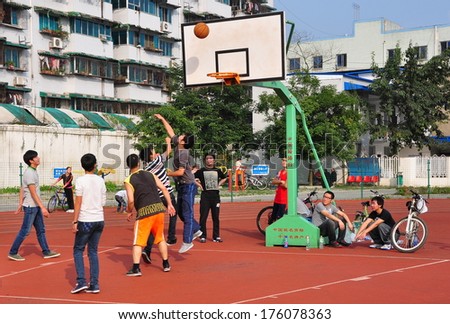 Pengzhou, China November 8, 2013: A group of Chinese youths playing basketball on a court in Pengzhou Stadium