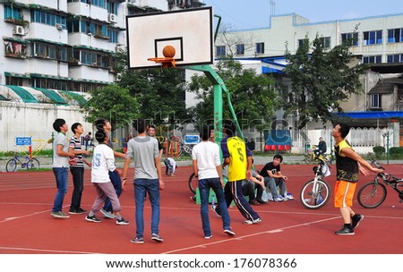Pengzhou, China November 8, 2013: A group of Chinese youths playing basketball on a court in Pengzhou Stadium