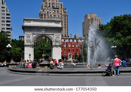 New York, NY - June 1, 2013:  Washington Square Park with its fountain and Triumphal Arch commemorating George Washington with Fifth Avenue luxury apartment towers