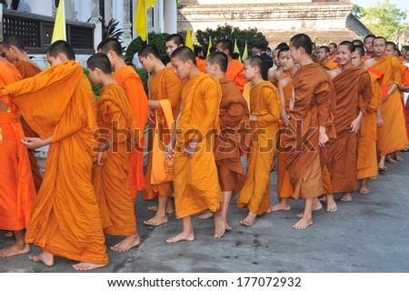 Chiang Mai, Thailand - December 19, 2012: Barefooted Novitiate Teenaged Monks Wearing Orange Robes Entering The Ubosot Sanctuary Hall For Morning Prayer At Wat Chedi Luang