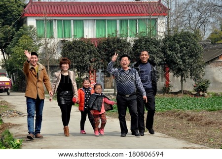 Pengzhou, China - March 8, 2014:  Smiling Chinese family walking along the driveway of the Sichuan province farmhouse