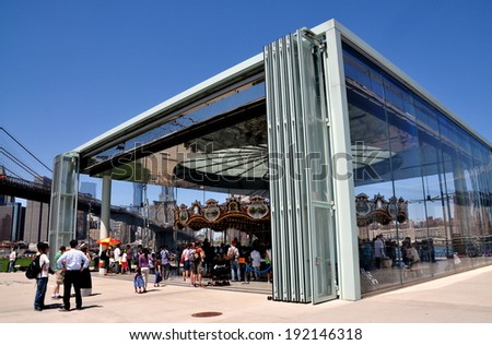 NYC - May 11, 2014:  A contemporary glass pavilion with sliding doors covers the finely restored 19th century James Carousel in Brooklyn Bridge Park