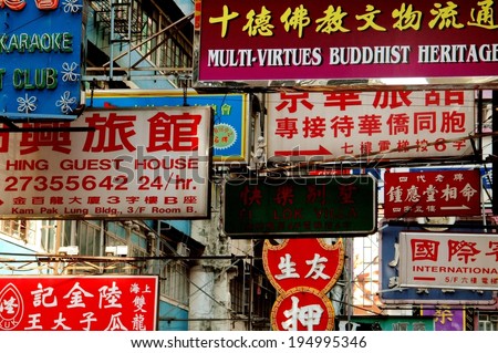 Hong Kong, China - December 17 2005:   A maze of commercial signs in both English and Chinese hang above a street in the busy Mong Kok district