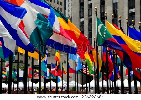 NYC - July 30, 2013:  Colourful flags of the world\'s nations line the sunken plaza with its famed gilded state of Prometheus at Rockefeller Center