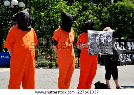 NYC - June 15, 2012:  Amnesty International demonstrators wearing orange jumpsuits and black hoods urge an end to worldwide torture by staging a demonstration in NYC\'s Union Square