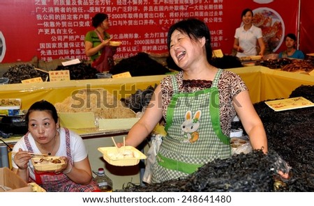 Chengdu, China - September 15, 2010:  Smiling woman selling dried seafood products at the 10th Chinese Moon Cake Festival at the annual Sichuan and Tianfu Food Fair