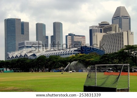 Singapore - December 12, 2007:  The historic Padang cricket field and Marina Square  modern towers skyline on the opposite shore of the Singapore River