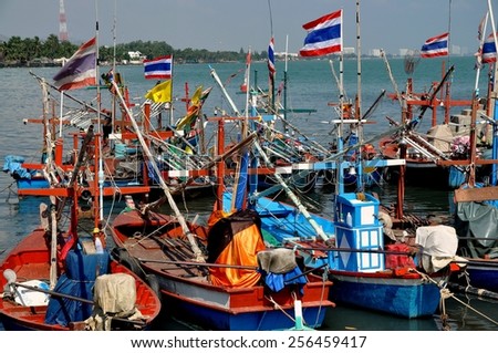 Hua Hin, Thailand - December 30, 2009:   A fleet of wooden fishing boats flying the Thai flag docked at the Hua Hin public fishing pier