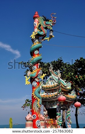 Hua Hin, Thailand - January 1, 2010:  A dragon with its long tail wrapped around a red pole at the Tewapitak Pok Pak Rom Yen Chinese temple