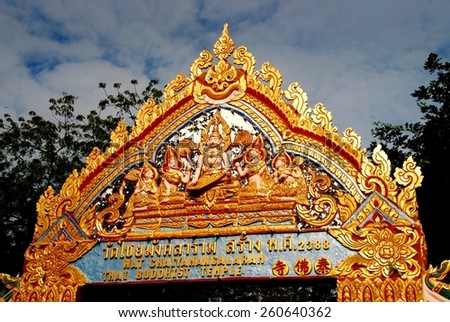 Georgetown, Malaysia - January 8, 2008:  Ornate gilded entry gate with carved Buddha figures at Wat Chaiyamangalaram Thai Buddhist Temple   *