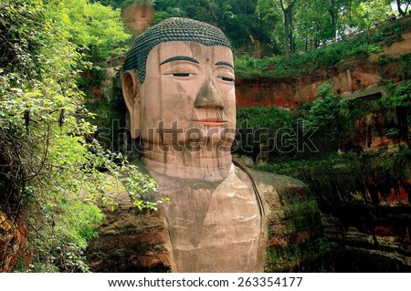 Leshan, China - April 25, 2005:  Face of the immense standing Buddha figure built in 713 A. D. sculpted out of a sandstone cliff and standing 71 meters in height