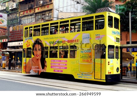 Hong Kong, China - December 16, 2007:  A double-decker tram covered in advertising runs along its tracks on Des Voeux Road at Central  *