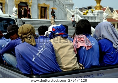 Bangkok, Thailand -  December 24, 2009:  Thai workers sitting in the back of a pickup truck in front of Wat Tramit in Chinatown