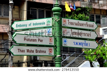 Bangkok, Thailand - January 19, 2012:  City street signs give destinations and distances in both English and Thai on Thanon Ratchadamri