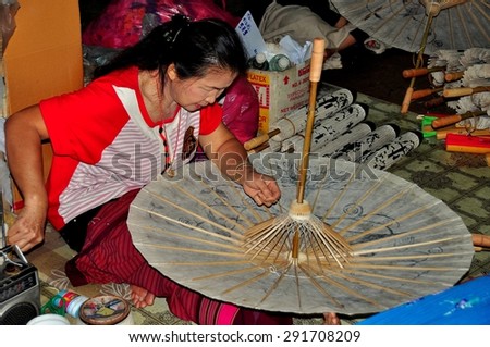 Chiang Mai, Thailand - December 31, 2012:  Thai woman crafting a paper parasol at the Sa Paper & Umbrella Handicraft Centre at Borsang Village  *