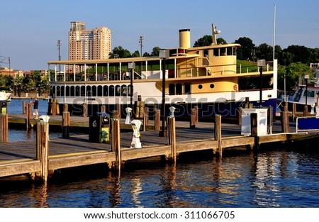 Baltimore, Maryland - July 23, 2013:  The Raven, an old-style double decked sightseeing boat with enclosed captain\'s cabin, moored at a quay in Inner Harbor