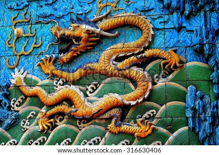 Beijing, China - May 2, 2005:  Tile bas relief dragon spewing fire on the Screen of Nine Dragons in the Forbidden City