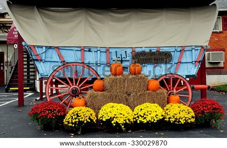 Bird-in-Hand, Pennsylvania - October 14, 2015:  Pennsylvania conestoga wagon with decorated with pumpkins, hay bales, and Chrysanthemums at the Bird-in-Hand Farmer\'s Market