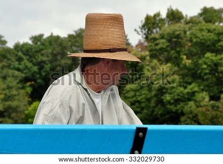 Lancaster, Pennsylvania - October 14, 2015:  Wagon driver wearing a tall straw hat at the Landis Valley Village and Farm Museum