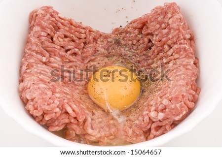 Fresh raw meat in a white bowl with a raw egg, preparing beef meat, isolated on white background image