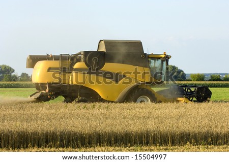 Yellow new holland Combine harvester view from the back at Corn earning time in summer