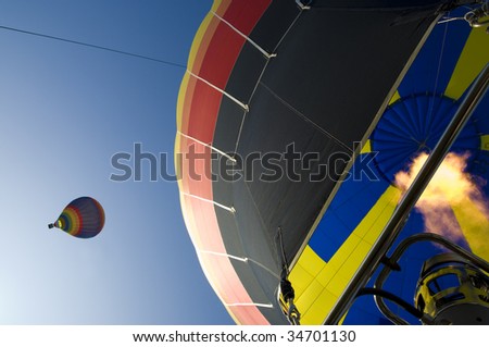 two hot air balloons together in the air, image taken from one balloons basket
