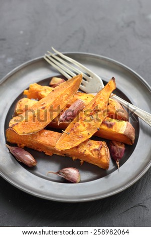 Sweet potato roasted chips on a tin plate.