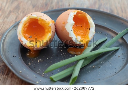 Two soft-boiled eggs on a tin plate.
