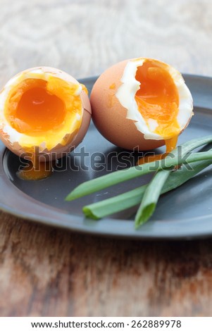 Two soft-boiled eggs on a tin plate.