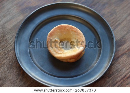 One piece of yorkshire pudding on a tin plate.