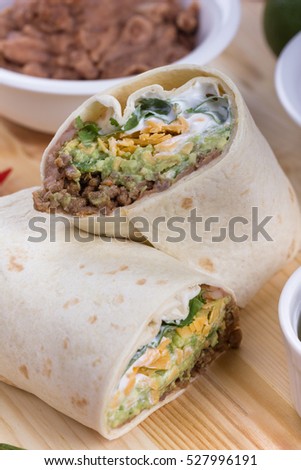 Beef tortilla with grated cheddar, guacamole, fried beans and chili.