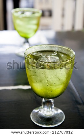 sparkling mineral water with ice in green cup.