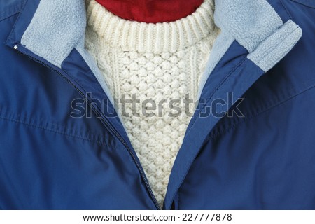 Blue fleece lined jacket with zip open over an Arran sweater for warm winter clothing