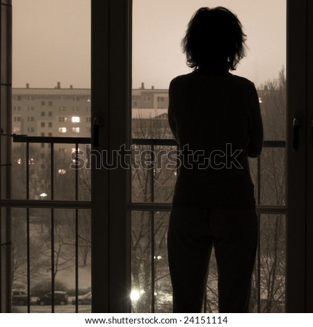 silhouette of woman looking out of window