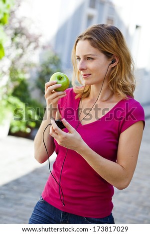 Woman Eating Fruit Listening to Music