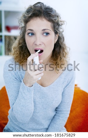 Woman Using Spray In Mouth