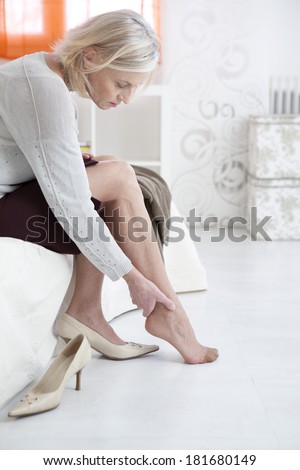 Senior lady suffering from a pain in her ankle