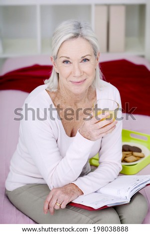 Senior woman drinking an orange juice.