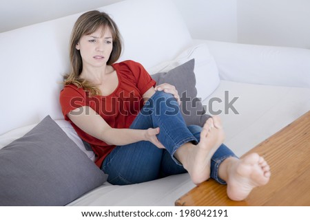 Woman suffering from leg pain.