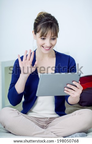 Senior woman chatting on tablet computer.