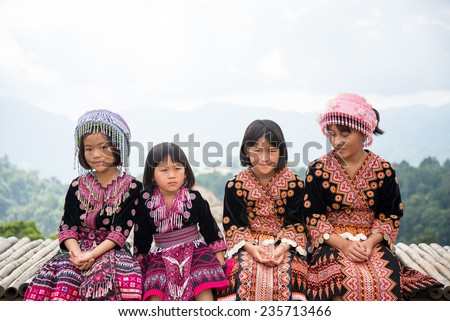 Chiangmai, THAILAND - OCT 26, 2014: Four young girl Mhongs sit on the chair with mountain view on October 26, 2014 in Chiangmai, Thailand