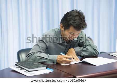 Asian adult education student struggles with test axam as anxiety as he takes an exam