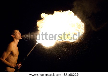 fire-eater performance on a street and audience on a dark background