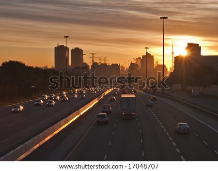 The beginning of morning rush hour, cars on the highway traveling to and from  downtown