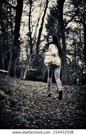 Teenage Girl Running Scared Away From Camera In Woods
