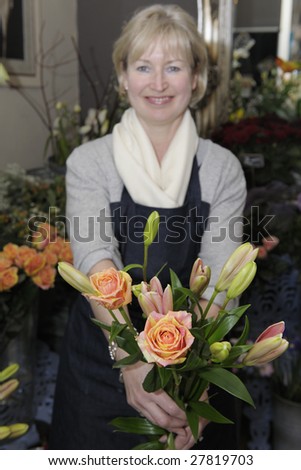 Florist picking flowers from her shop to make a bouquet