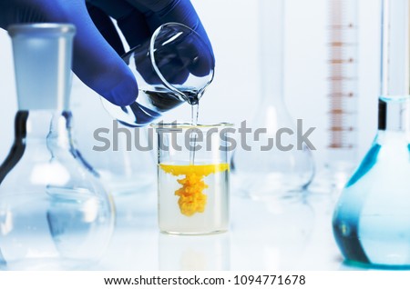 Chemical reaction. Two clear liquids are mixed to produce a yellow precipitate.