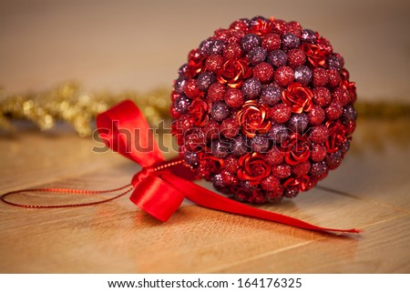 Closeup of red Christmas ball on background with wooden deck floor